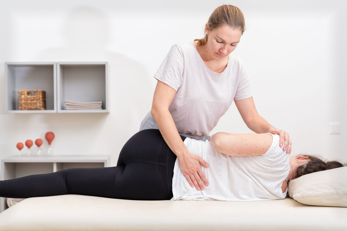 Kerstin König behandelt eine Patientin auf der Therapieliege